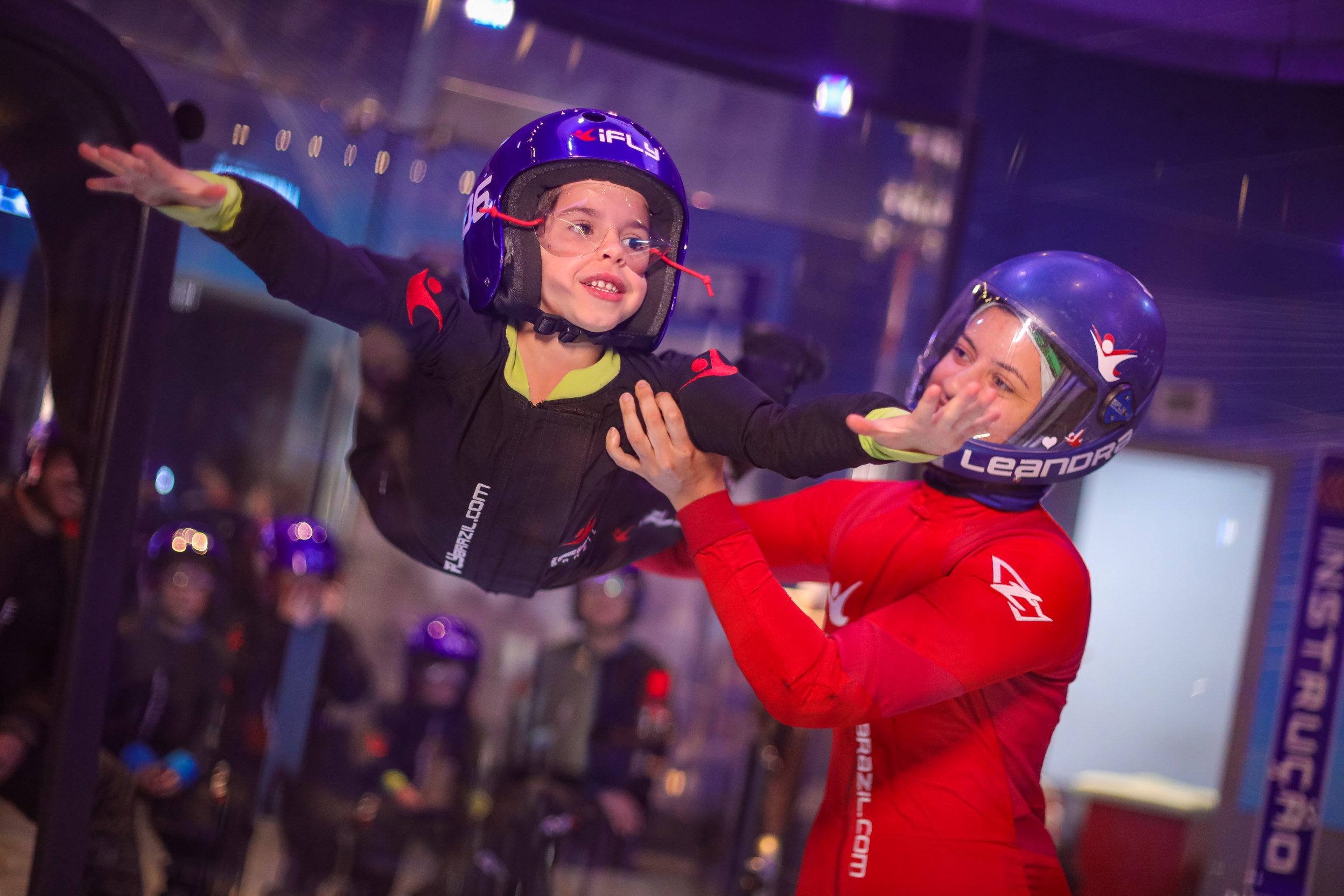 Instrutor da iFLY voando com uma criança